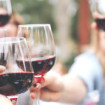 Wine gift basket ideas for 2023 with people cheersing